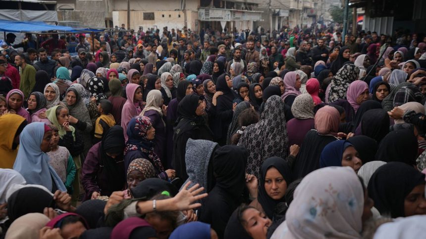 Palestinians gather to get food at a distribution center in Deir al-Balah, Gaza Strip, Friday Nov.29, 2024. Earlier, two children and a 50-year-old woman were crushed to death as a crowd of Palestinians pushed to get bread at one of the bakeries in Deir al-Balah, medical officials said. (AP Photo/Abdel Kareem Hana)