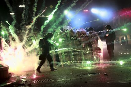 Demonstrators use firecrackers against police as police block a street to prevent protesters rallying against the government's decision to suspend negotiations on joining the European Union for four years, outside the parliament's building in Tbilisi, Georgia, on Nov. 30, 2024.