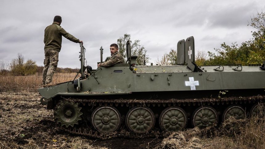 Two Ukrainian army mechanics repair a broken MT-LB (light armored multi-purpose towing vehicle) in the Donetsk region in Kharkiv, Ukraine on October 25, 2024.