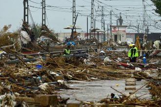 Agents stand amid debris during rain in Paiporta, south of Valencia, eastern Spain, on November 13 in the aftermath of deadly flooding.