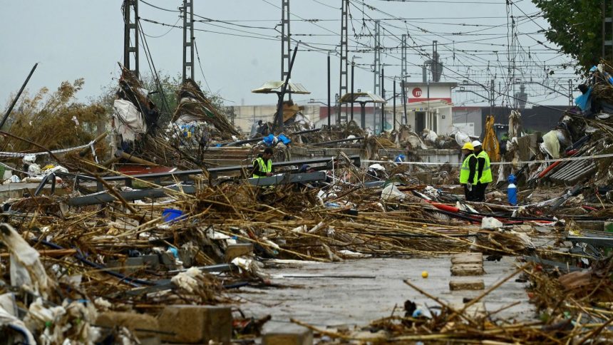 Agents stand amid debris during rain in Paiporta, south of Valencia, eastern Spain, on November 13 in the aftermath of deadly flooding.