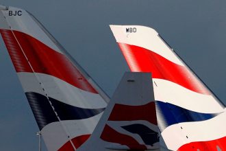 Sunlight illuminates the tailfins of British Airways aircraft at Terminal 5 of London Heathrow Airport on February 5, 2021