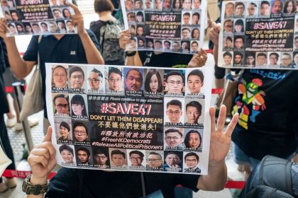 Supporters hold signs featuring images of some of the 47 pro-democracy activists outside the West Kowloon Magistrates' Courts ahead of a hearing in Hong Kong, China, on July 8, 2021.