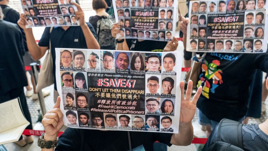 Supporters hold signs featuring images of some of the 47 pro-democracy activists outside the West Kowloon Magistrates' Courts ahead of a hearing in Hong Kong, China, on July 8, 2021.