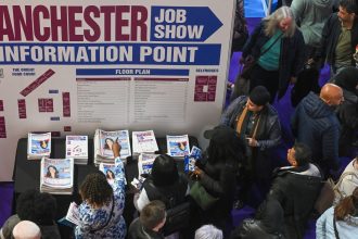 Visitors collect copies of a free newspaper at the Manchester Job Show in Manchester, UK, on Friday, April 28, 2023. The number of people available to work in the UK rose for the first time in two years, easing one of the tightest labor markets in more than a generation, a survey compiled by S&P Global showed. Photographer: Anthony Devlin/Bloomberg via Getty Images