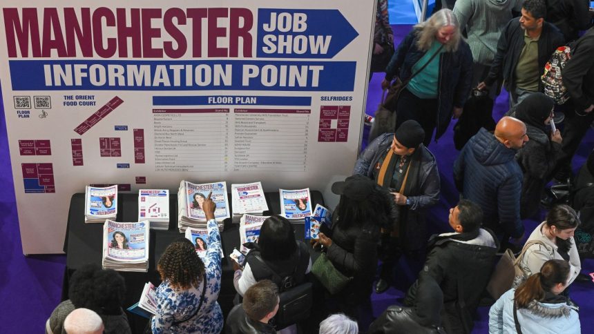 Visitors collect copies of a free newspaper at the Manchester Job Show in Manchester, UK, on Friday, April 28, 2023. The number of people available to work in the UK rose for the first time in two years, easing one of the tightest labor markets in more than a generation, a survey compiled by S&P Global showed. Photographer: Anthony Devlin/Bloomberg via Getty Images