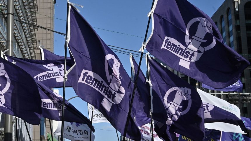 South Korean women carry flags reading "feminist" during a rally in Seoul earlier this year to mark International Women's Day.