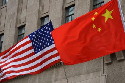 The national flags of the United States and China flutter at the Fairmont Peace Hotel on April 25, 2024 in Shanghai, China.