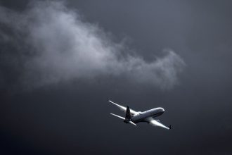 A Virgin Australia Airlines plane flies as a storm approaches at Sydney International Airport on June 7.