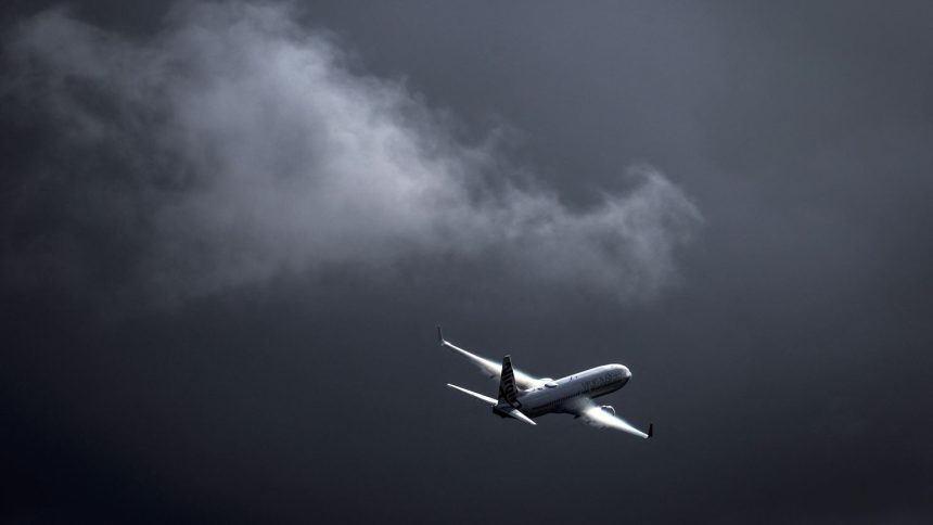 A Virgin Australia Airlines plane flies as a storm approaches at Sydney International Airport on June 7.