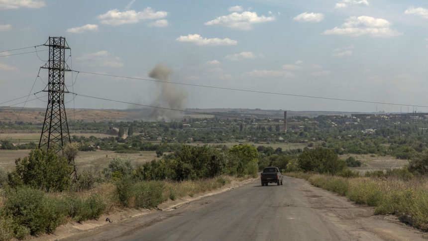 A vehicle drives as smoke rises from the town of Siversk, close to the frontline in the eastern Donetsk region.