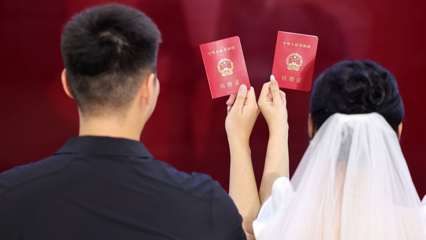 A newlywed couple pose for a photo at the marriage registration office Linyi, China on August 10, 2024.