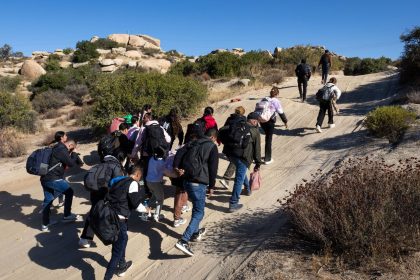 Colombian asylum seekers walk along a desert road after crossing the US-Mexico border near Jacumba Hot Springs, California on September 22, 2024.