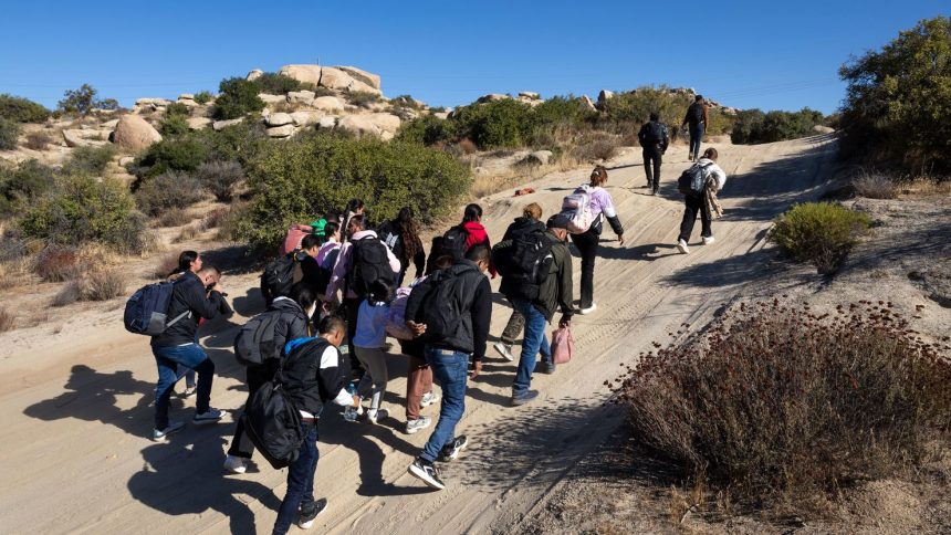 Colombian asylum seekers walk along a desert road after crossing the US-Mexico border near Jacumba Hot Springs, California on September 22, 2024.