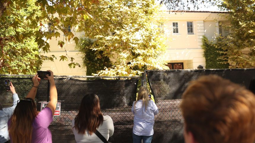 Visitors take photos of the Menendez brothers' former mansion in Beverly Hills, California, on October 23, 2024.