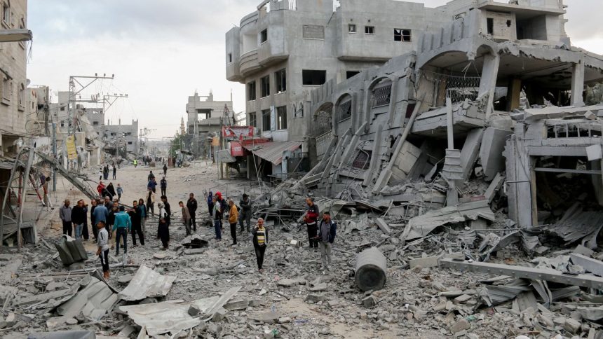 Residents walk through streets of rubble in the Al-Zawaida area of the Gaza Strip on November 1.