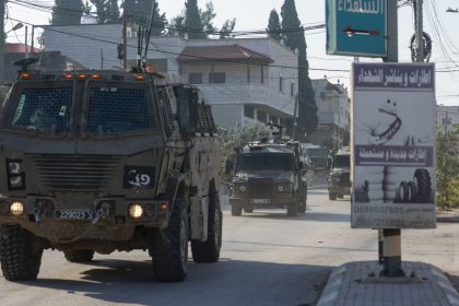 Israeli army vehicles drive down a road during a raid in Qabatiya, south of Jenin city in the occupied West Bank on November 5, 2024.