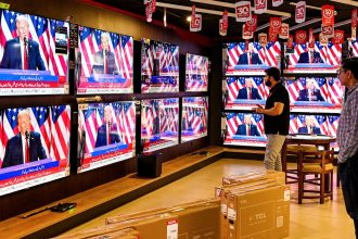 Men watch a television broadcast at a shop in Islamabad, Pakistan, on November 6, 2024, featuring Donald Trump as he addresses an election night event in the US state of Florida.