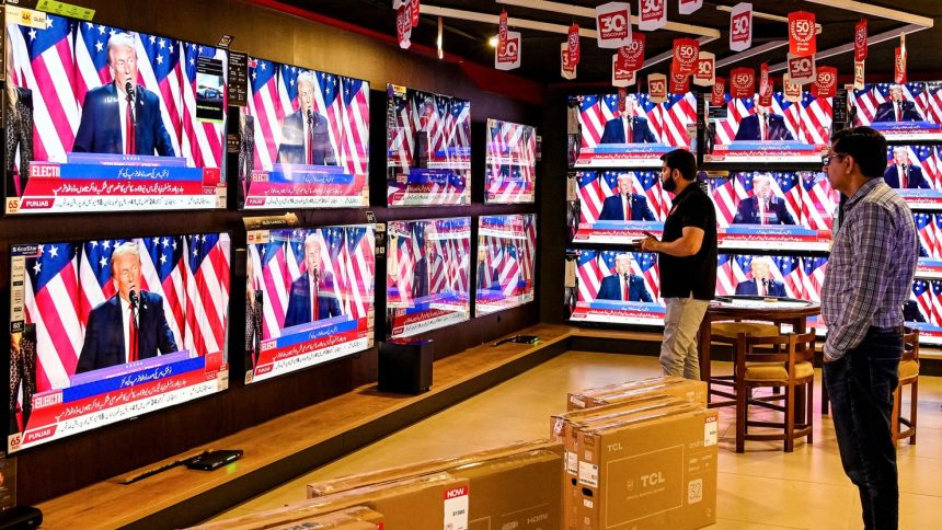 Men watch a television broadcast at a shop in Islamabad, Pakistan, on November 6, 2024, featuring Donald Trump as he addresses an election night event in the US state of Florida.