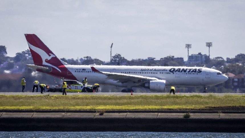 Workers check the runway at Sydney International Airport following an emergency landing by a Qantas plane (not the aircraft pictured here).