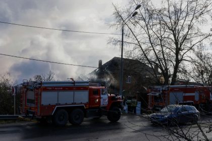 Rescuers stand next to a damaged house following a drone attack in the village of Stanovoye, Moscow region, on Sunday.