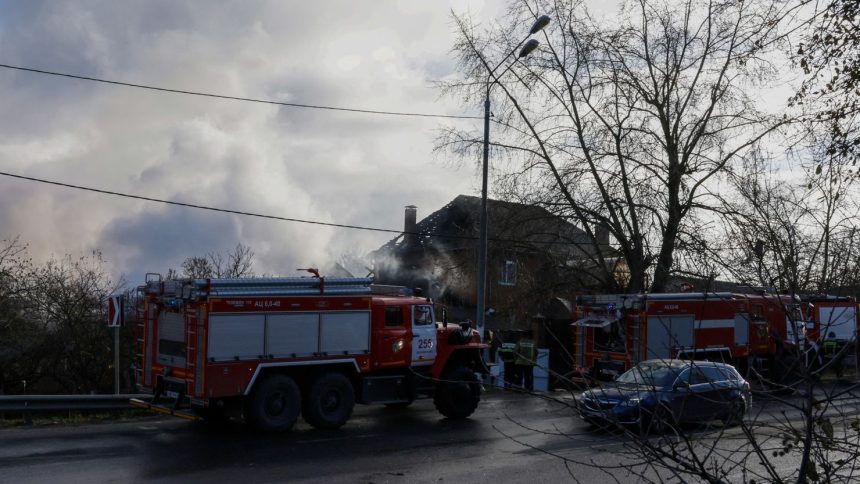 Rescuers stand next to a damaged house following a drone attack in the village of Stanovoye, Moscow region, on Sunday.