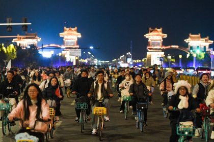 College students from Zhengzhou cycle to Kaifeng, 30 miles away, at night on November 9, 2024 in Henan Province of China.