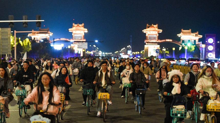 College students from Zhengzhou cycle to Kaifeng, 30 miles away, at night on November 9, 2024 in Henan Province of China.