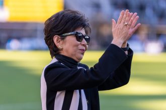 Washington Spirit owner Michele Kang waves to the crowd during a NWSL playoff semifinal game between NJ/NY Gotham FC and Washington Spirit at Audi Field on November 16.