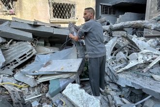 A Palestinian inspects the rubble of a building in Beit Lahia, in the northern Gaza Strip, on November 21, 2024, as the war between Israel and Palestinian Hamas militants continues.