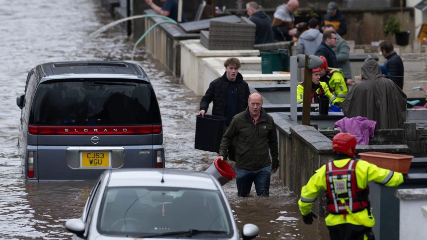 People wade through water on Sion Street in Pontypridd, Wales on November 24, 2024.