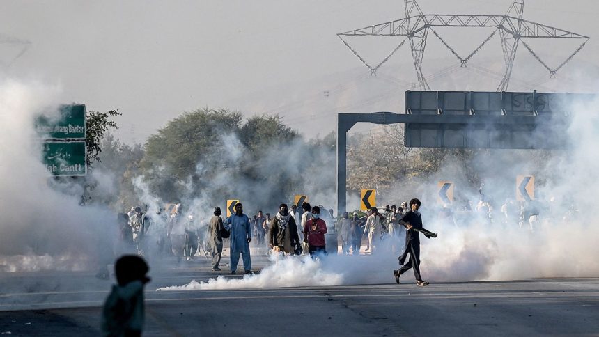 Protesters throw back teargas shells fired by riot policemen during a march to Islamabad demanding the release of former Prime Minister Imran Khan in Hasan Abdal in Punjab province on November 25, 2024.