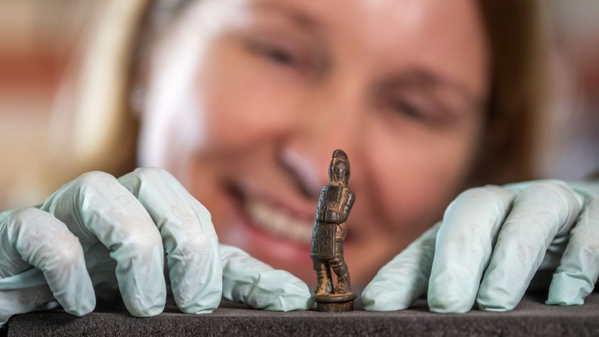 English Heritage curator Frances McIntosh examines a newly discovered Roman knife handle cast in the shape of a "secutor" gladiator.