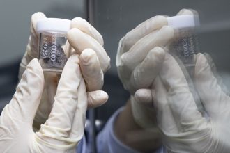 A researcher shows a lunar sample retrieved by the Chang'e-6 mission at the lunar sample laboratory in the National Astronomical Observatories of the Chinese Academy of Sciences in Beijing in September.