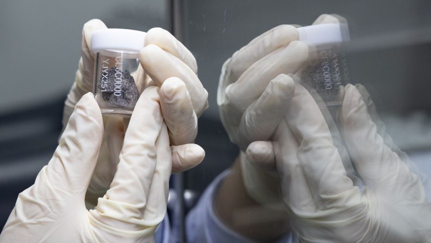 A researcher shows a lunar sample retrieved by the Chang'e-6 mission at the lunar sample laboratory in the National Astronomical Observatories of the Chinese Academy of Sciences in Beijing in September.