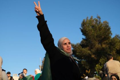 A young woman joins the celebrations of the collapse of the Assad regime.