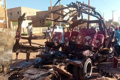 People gather near a destroyed vehicle, following shelling by the Rapid Support Forces, in Omdurman, Sudan, December 10, 2024.