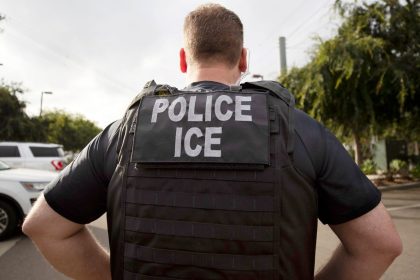 FILE - A U.S. Immigration and Customs Enforcement (ICE) officer looks on during an operation in Escondido, Calif.,  July 8, 2019.  Immigration enforcement arrests in the interior of the U.S. fell over the past year as the Biden administration shifted its enforcement focus to people in the country without legal status who have committed serious crimes.