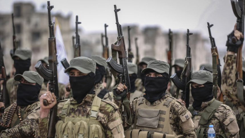 Fighters from the Popular Resistance Brigades, a local militia, take part in a military parade in Idlib city during their graduation from a military course in the presence of the prime minister of the Syrian Salvation Government on February 17, 2022.