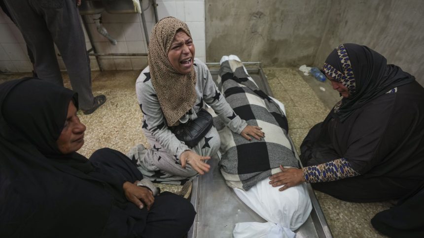 Relatives mourn over the body of 17-year-old Rahaf Abu Laban in Deir al-Balah after she was crushed to death as a crowd of Palestinians pushed to get bread at a bakery.