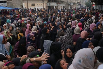 Palestinians gather to get food at a distribution center in Deir al-Balah, Gaza Strip, Friday Nov.29, 2024. Earlier, two children and a 50-year-old woman were crushed to death as a crowd of Palestinians pushed to get bread at one of the bakeries in Deir al-Balah, medical officials said. (AP Photo/Abdel Kareem Hana)