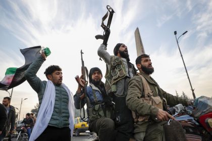 Syrian opposition fighters celebrate after the Syrian government collapsed in Damascus, Syria, Sunday, Dec. 8, 2024. (AP Photo/Omar Sanadiki)