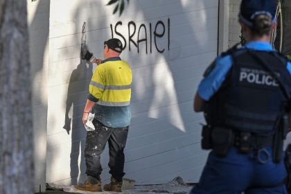 A contractor cleans anti Israel graffiti from a wall in the Sydney suburb of Woollahra, Australia, Wednesday, Dec. 11, 2024.