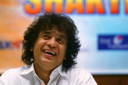 Zakir Hussain laughs during a press conference to announce a musical concert in Mumbai, India, on December 8, 2006.