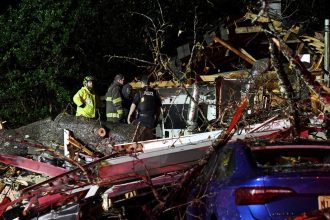 First responders work to free a person after a tree fell on a house in Natchez, Mississippi, on Saturday.