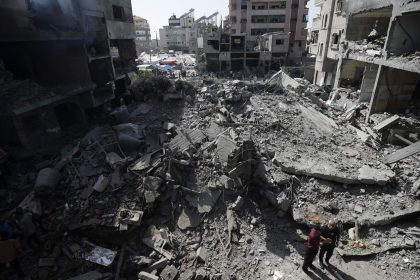 Palestinians look at the aftermath of an Israeli bombing in Nuseirat refugee camp in the Gaza Strip in June.