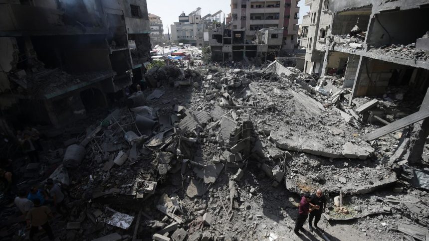 Palestinians look at the aftermath of an Israeli bombing in Nuseirat refugee camp in the Gaza Strip in June.