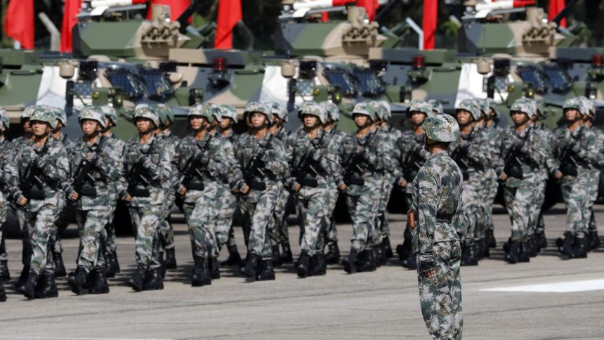 In this 2017 photo, People's Liberation Army troops march during a visit by Chinese President Xi Jinping, not pictured, at the Shek Kong Barracks in Hong Kong.