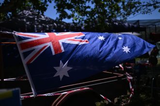 TAMWORTH, AUSTRALIA - JANUARY 26: The Australian flag is attached to a trailer at a campground during Australia Day on January 26, 2024 in Tamworth, Australia. Australia Day, formerly known as Foundation Day, is the official national day of Australia and is celebrated annually on January 26 to commemorate the arrival of the First Fleet to Sydney in 1788. Many indigenous Australians refer to the day as Invasion Day and there is a growing movement to change the date to one which can be celebrated by all Australians. In 2024, supermarket chains Woolworths and Aldi announced that they will stop stocking themed merchandise for the day, drawing a political backlash from opposition leader Peter Dutton. (Photo by Dan Peled/Getty Images)