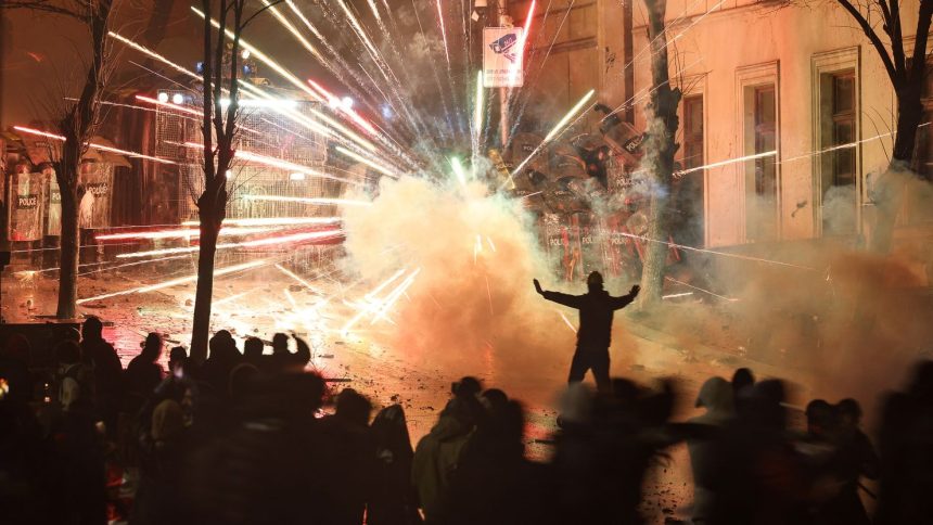 Fireworks explode as protesters clash with police outside the Georgia parliament during a demonstration in Tbilisi, early on December 1, 2024.